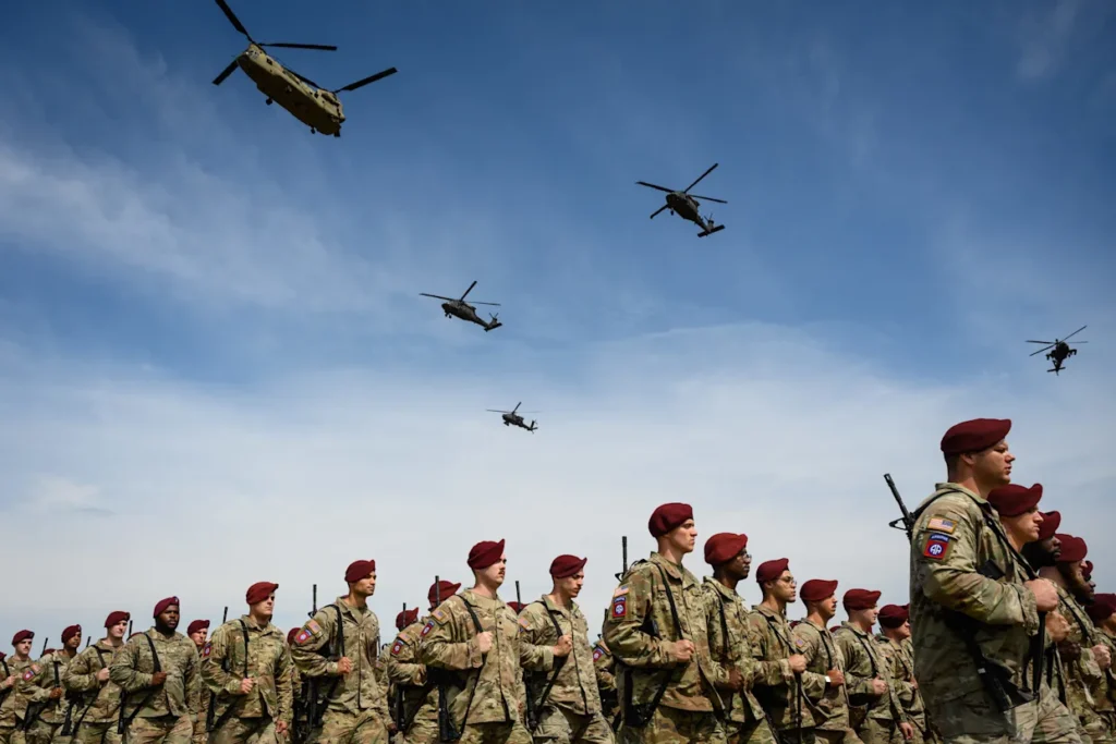 Trump fala em paz com o Irã enquanto manda tropas - O que está por trás desse plano de paz? 3 Paraquedistas da 82ª Divisão Aerotransportada em formação com helicópteros na cerimônia em Fort Bragg