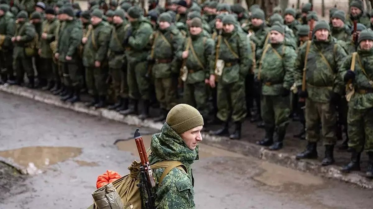 Ucrânia diz que Rússia prepara mobilização de 600 mil homens para 2026 e 2027 2 Recrutas russos em formação com fuzis e mochilas em dia chuvoso, foto de arquivo.