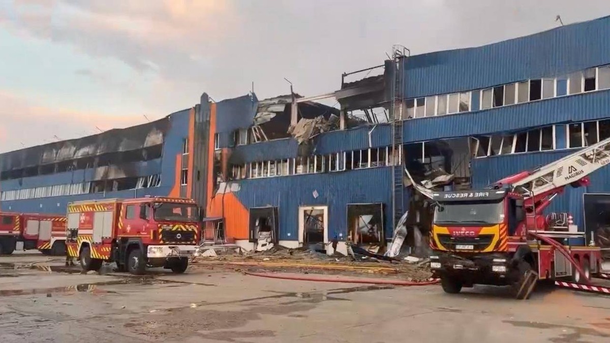 Ataque russo destrói centros logísticos civis e mata 17 na região de Kiev 1 Fachada azul e laranja do armazém da Rozetka em Brovary destruída por ataque russo, com caminhões de bombeiros em frente ao prédio